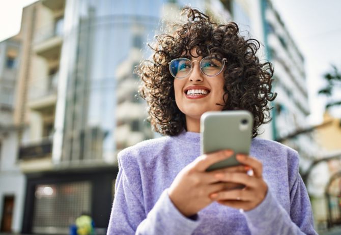 Woman with curly hair using phone