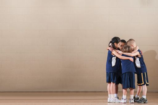 Young basketball players in group huddle